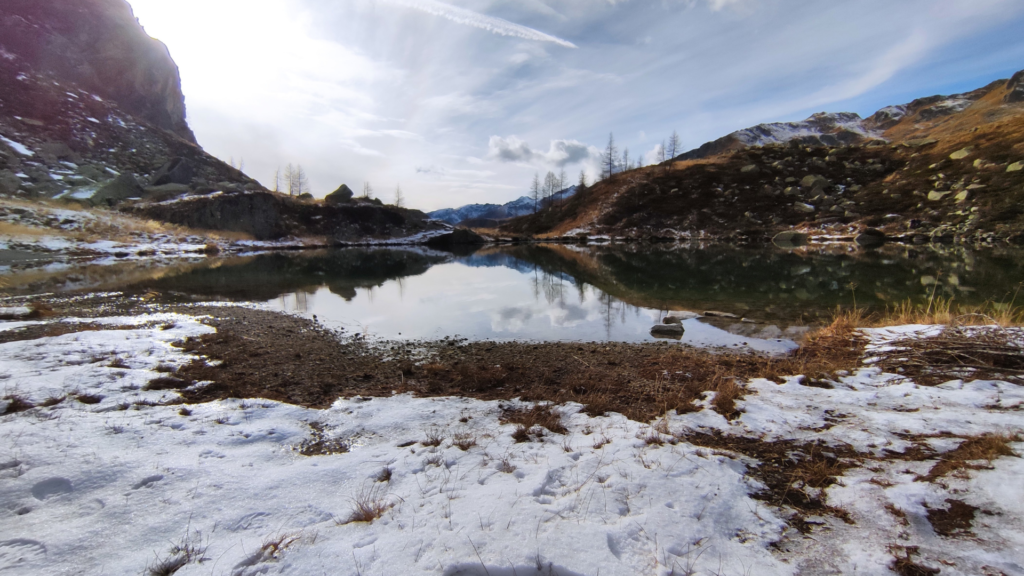 Il lalbrasotto al lago degli asini, un lago nascosto tra le vette delle montagne, circondato dalla neve e dai colori freddi.